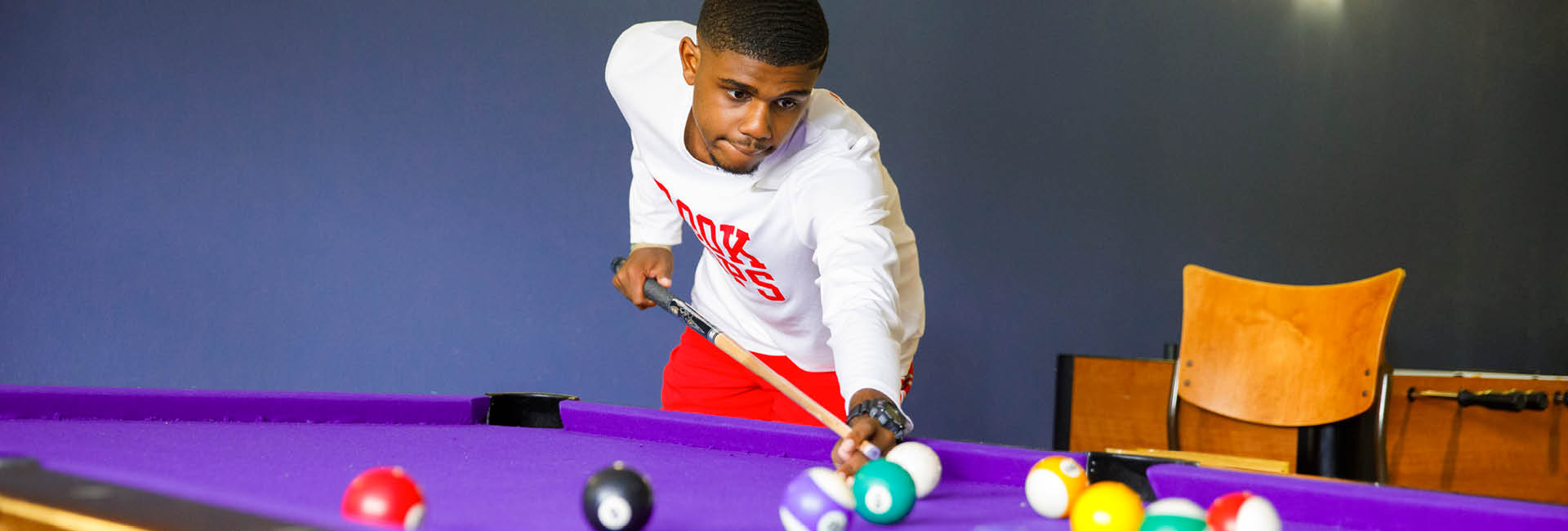 Student playing pool in a Res Hall