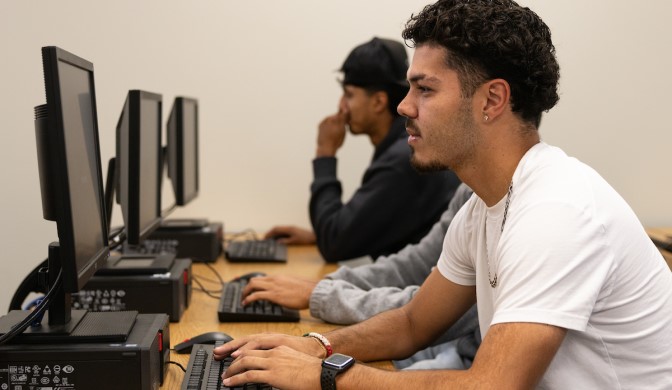 A Concordia student on campus working in a computer lab