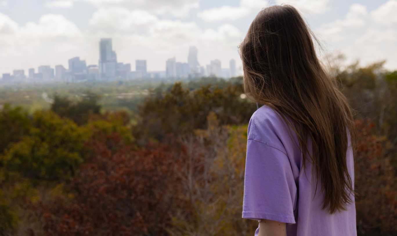 Student looking out at Austin skyline