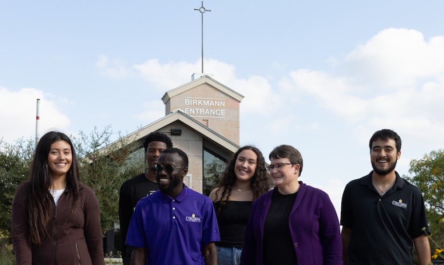 A group at the Birkmann Entrance of campus