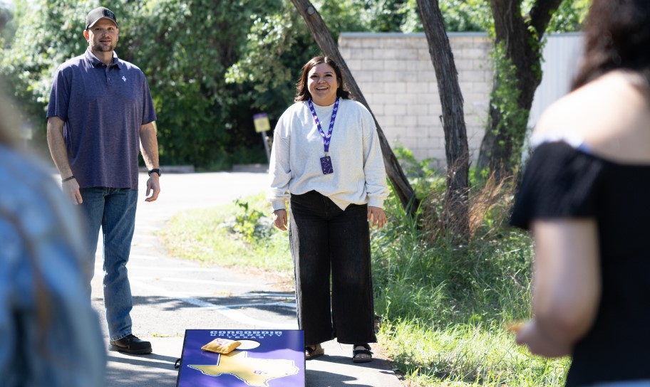 Students playing a game of corn hole.
