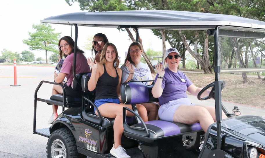 A group from Concordia Texas on using a golf cart on campus