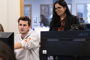 Computer science professor helping a student in a computer lab