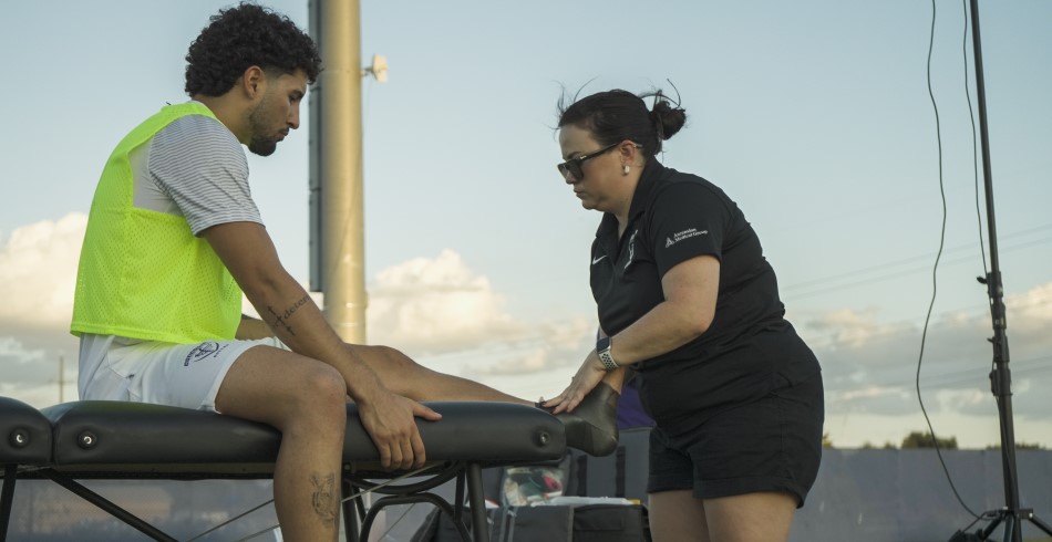 An athlete being checked out by a trainer